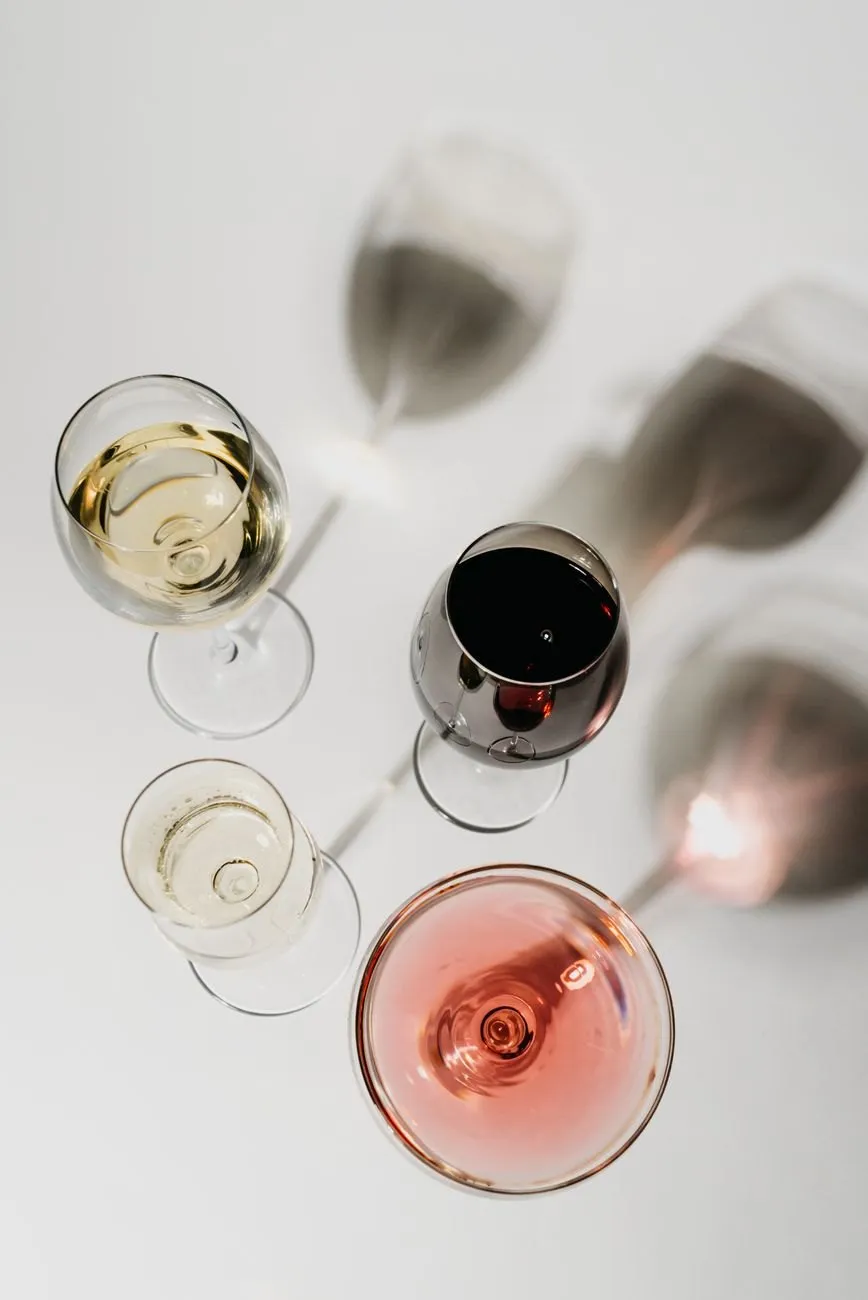 Four glasses of wine seen from above, casting long shadows