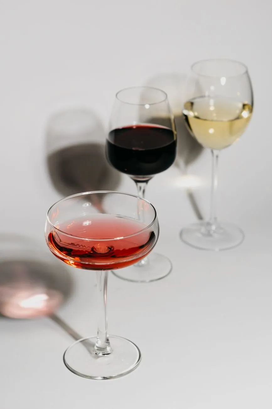 A coupe of pink wine beside glasses of red and white