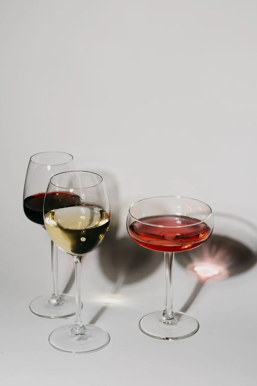 Glasses of red, white and rosé wine on a pale surface