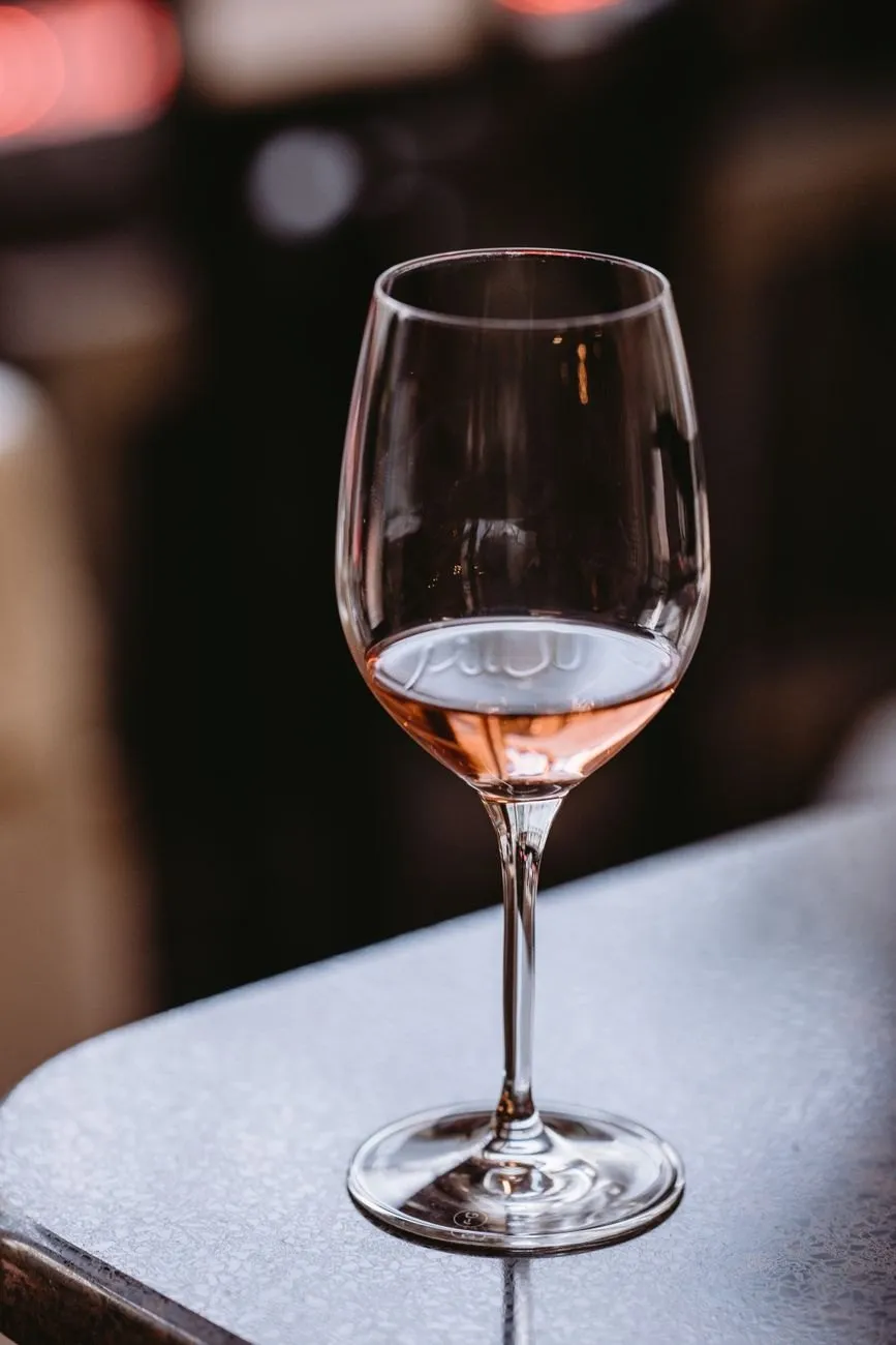 A single glass of pale copper-pink rosé on a table